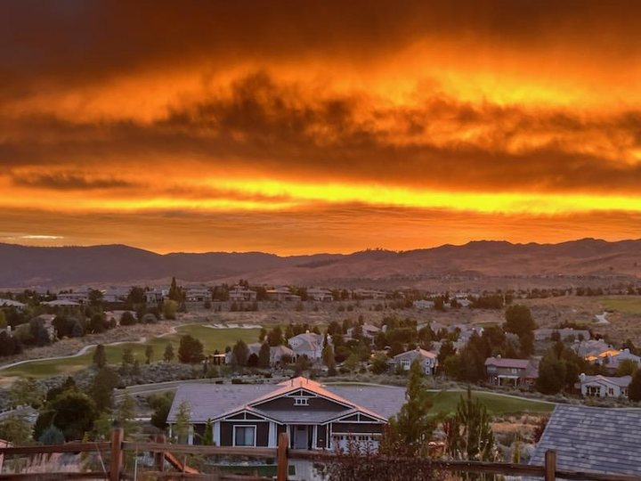 A fiery orange sunset over Somersett homes, the golf course and the hills beyond.